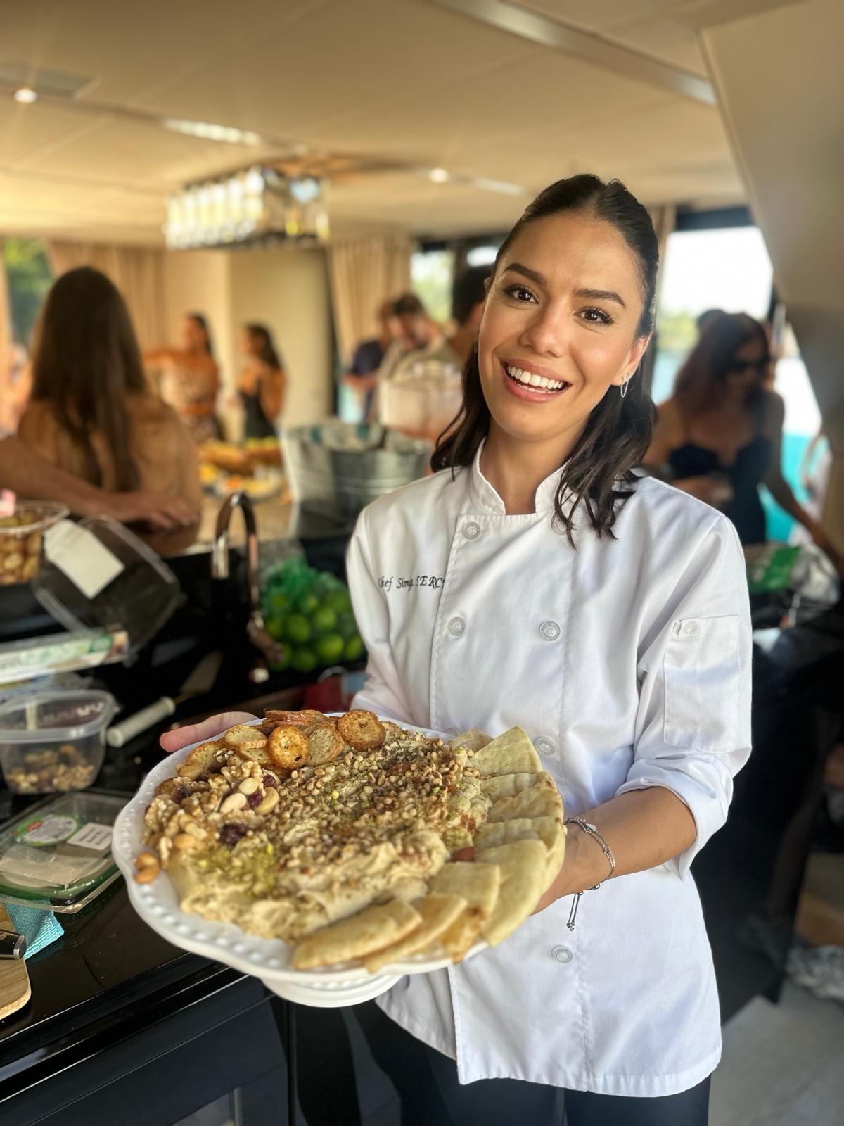 Chef Simge serving food on a yacht